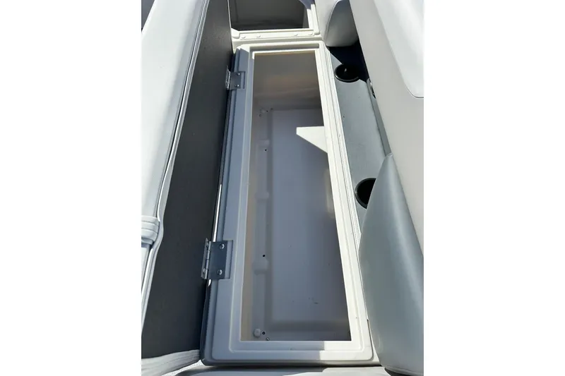 Slide: The Image of Open storage compartment in 2026 Sweetwater SW2086CPSE boat, featuring cup holders and cushioned seating. - 31