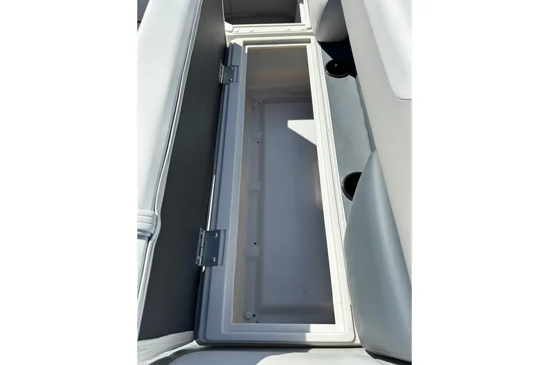 Slide: The Image of Open storage compartment in 2026 Sweetwater SW2086CPSE boat, featuring cup holders and cushioned seating. - 33