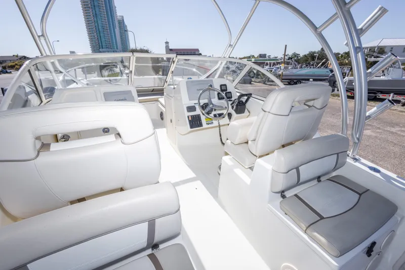 Slide: The Image of Interior view of a 2016 World Cat 255 DC boat with white seating and steering console. - 25