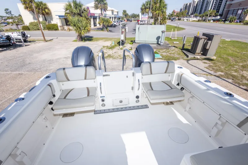 Slide: The Image of 2016 World Cat 255 DC boat interior with seating and dual engines, parked near a road. - 26