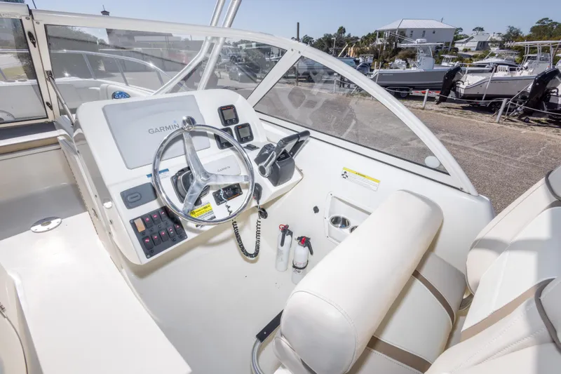 Slide: The Image of 2016 World Cat 255 DC boat cockpit with Garmin navigation system and steering wheel. - 27