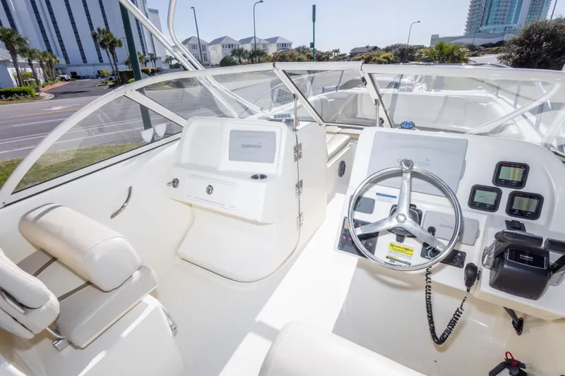 Slide: The Image of Interior of a 2016 World Cat 255 DC boat with steering wheel and navigation equipment. - 28