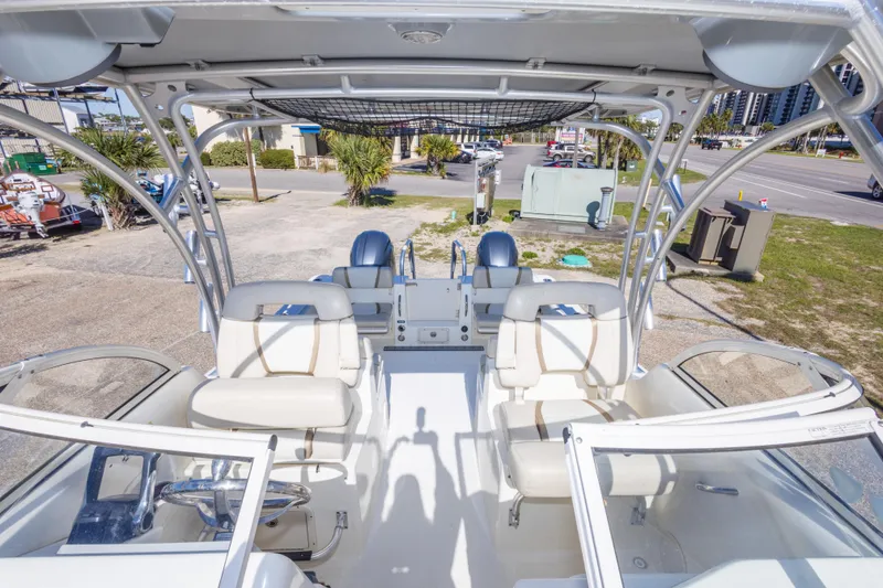 Slide: The Image of 2016 World Cat 255 DC boat interior with seating and steering wheel, parked outdoors. - 33