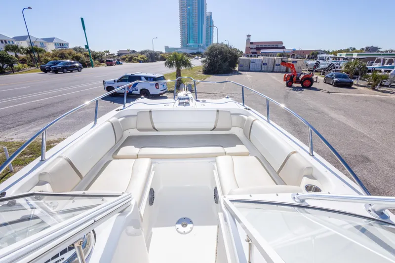 Slide: The Image of 2016 World Cat 255 DC boat with spacious seating, parked near a road and buildings. - 35