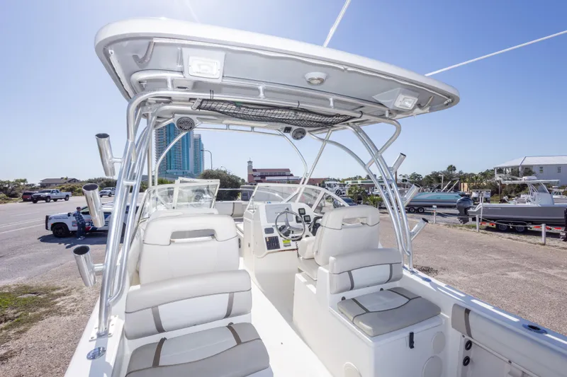 Slide: The Image of 2016 World Cat 255 DC boat interior with dual console and seating, parked near marina. - 41