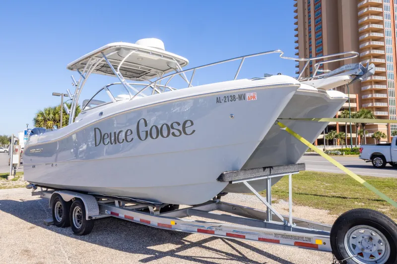 Slide: The Image of 2016 World Cat 255 DC boat named "Deuce Goose" on a trailer near a tall building. - 7