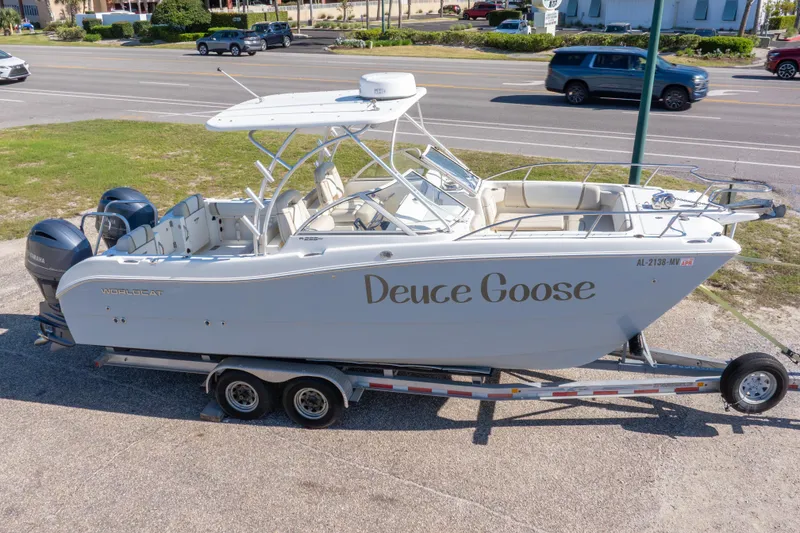 Slide: The Image of 2016 World Cat 255 DC boat named "Deuce Goose" on trailer, parked near road. - 8