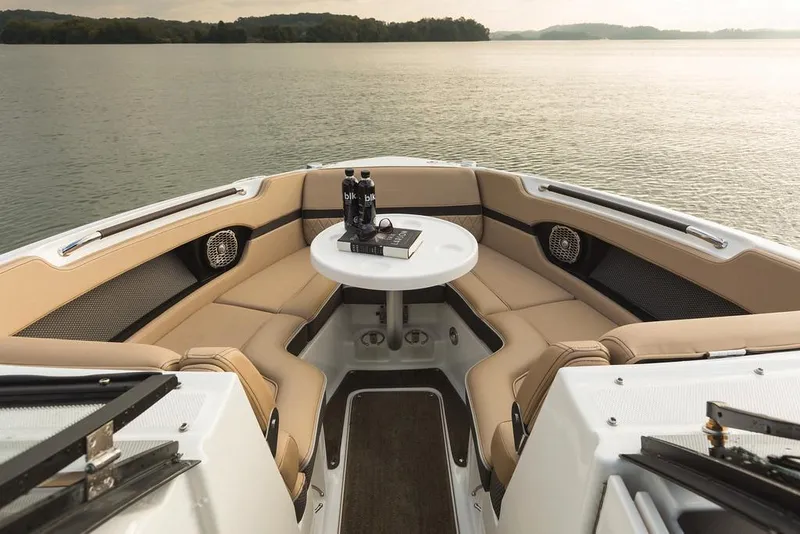 Slide: The Image of Manufacturer Provided Image: 2018 Sea Ray SLX 280 boat interior with tan seating and round table on calm water. - 4