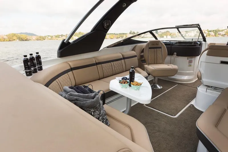 Slide: The Image of Manufacturer Provided Image: 2018 Sea Ray SLX 280 boat interior with beige seating and snack table. - 8