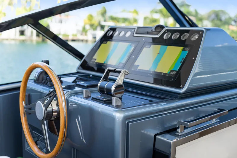 Slide: The Image of 2024 CNM CONTINENTAL 54 SuperSport yacht dashboard with dual navigation screens and wooden steering wheel. - 36