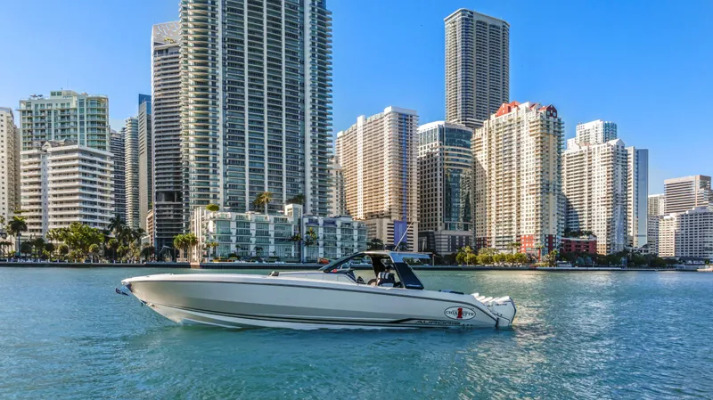 Slide: The Image of 2022 Cigarette 42 Auroris boat cruising near city skyscrapers on a sunny day. - 5