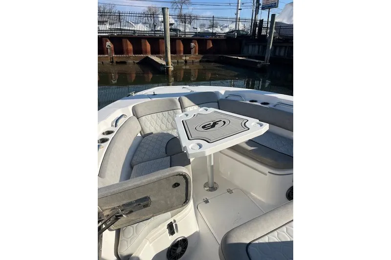 Slide: The Image of 2021 Sea Fox 228 Commander boat interior with seating and table, docked by water. - 28