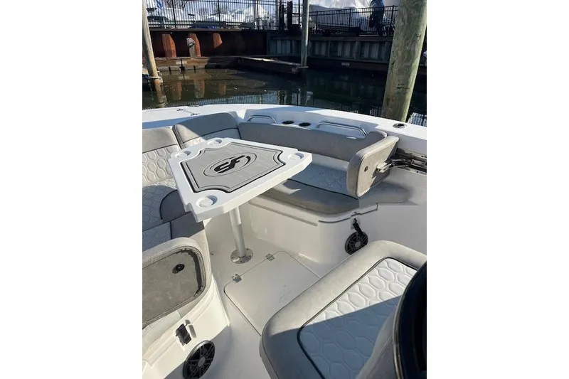 Slide: The Image of 2021 Sea Fox 228 Commander boat interior with seating and table, docked by water. - 29