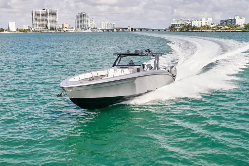 The Image of 2022 Midnight Express 43 Open boat cruising on turquoise water near city skyline. - 0
