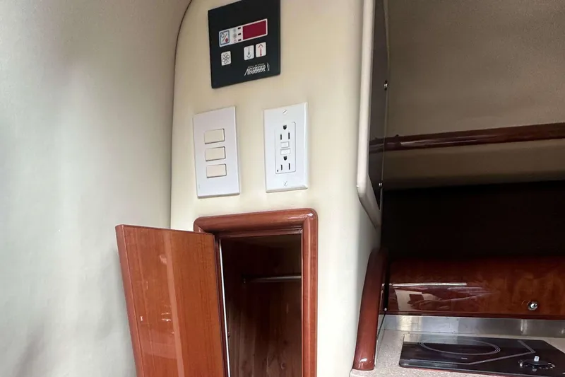 Slide: The Image of Interior of a 2008 Cobalt 323 boat featuring control panel and wooden cabinetry. - 14