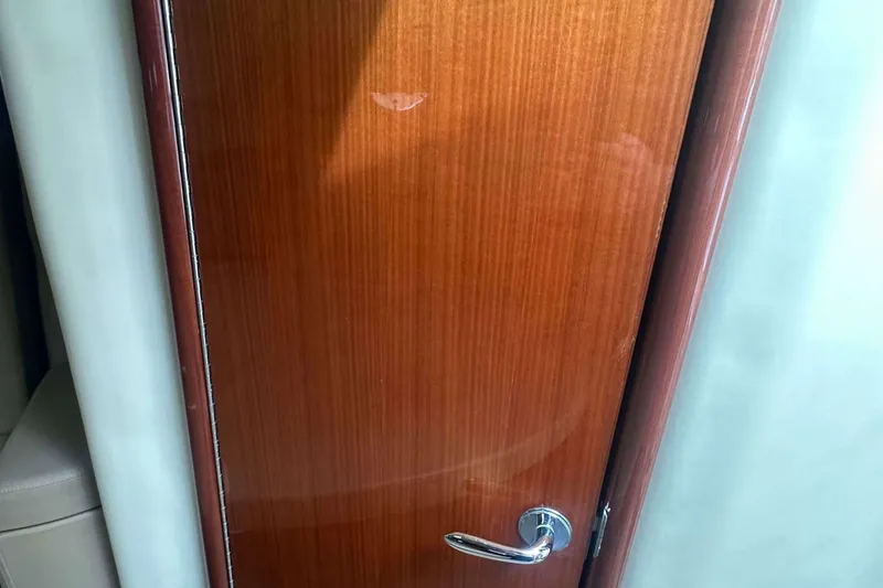 Slide: The Image of Wooden door with chrome handle on a 2008 Cobalt 323 boat interior. - 15
