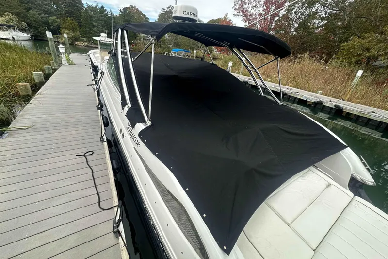 Slide: The Image of 2008 Cobalt 323 boat docked with black cover, surrounded by lush greenery. - 20
