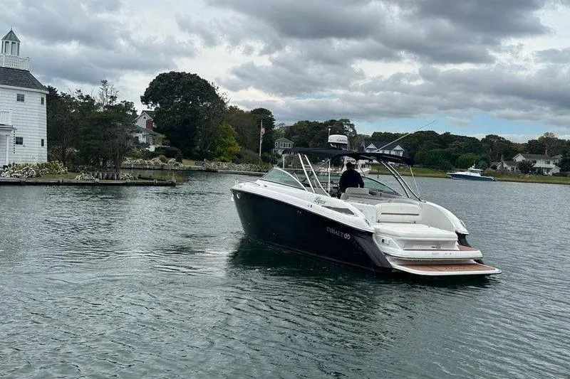 Slide: The Image of 2008 Cobalt 323 boat cruising on a calm lake near a lighthouse. - 3