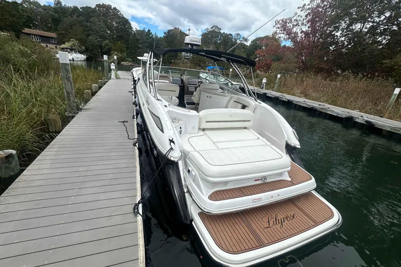 Slide: The Image of 2008 Cobalt 323 boat docked on a serene lake with lush greenery. - 6