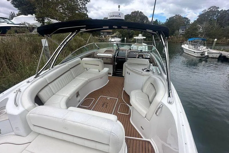 Slide: The Image of 2008 Cobalt 323 boat with white seating and wood deck, docked in a serene waterway. - 7