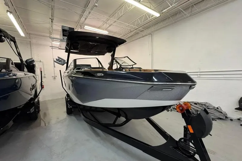 Slide: The Image of 2026 Malibu Wakesetter 25 LSV boat in showroom, sleek design, black and white color. - 3