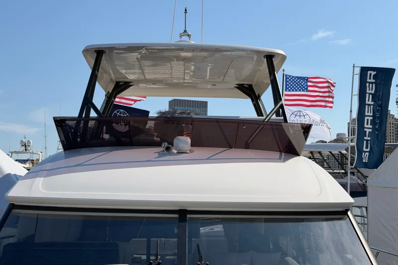 Slide: The Image of 2023 Prestige 520 yacht with American flags and Schaefer Yachts banner in background. - 22