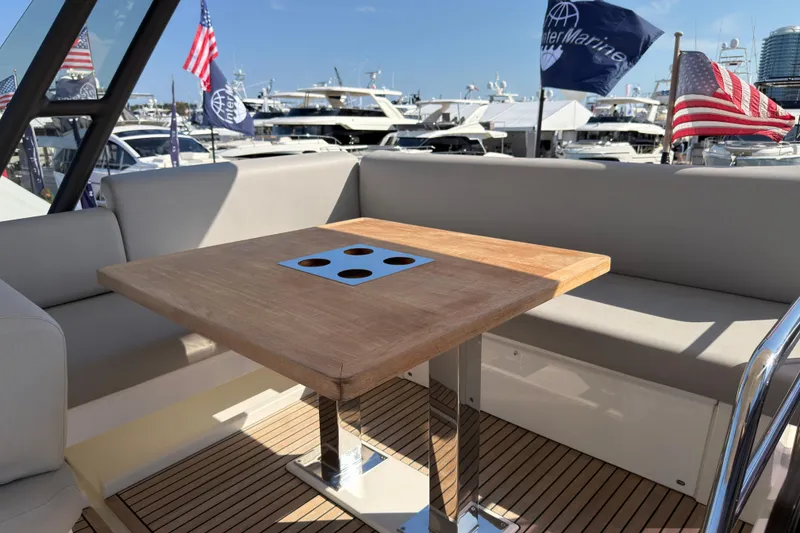 Slide: The Image of Luxurious 2023 Prestige 520 yacht deck with wooden table and seating area. - 25