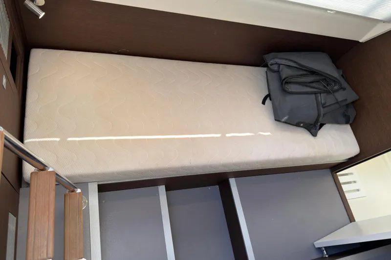 Slide: The Image of 2023 Prestige 520 yacht interior with a single bed and folded bag. - 26