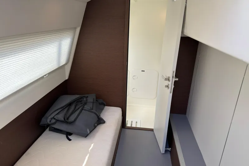 Slide: The Image of 2023 Prestige 520 yacht interior cabin with bed and open door to bathroom. - 27