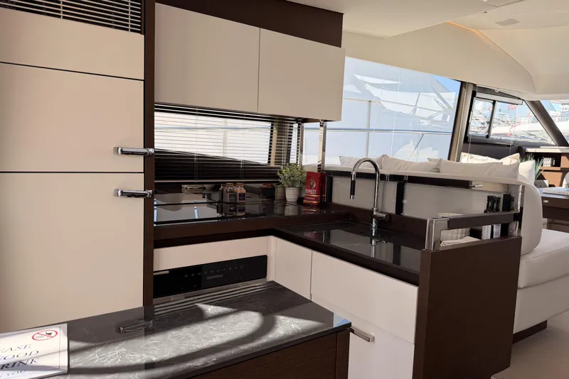 Slide: The Image of Modern kitchen interior on 2023 Prestige 520 yacht, featuring sleek cabinetry and stainless steel fixtures. - 5