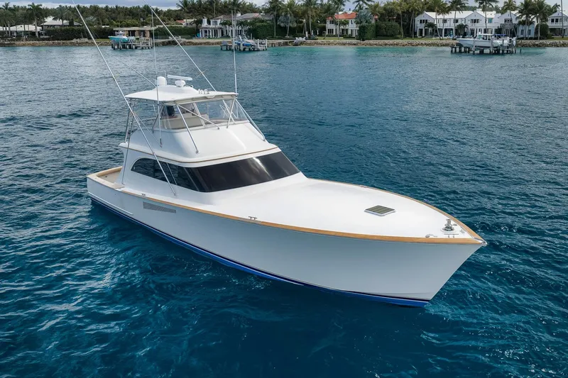 Slide: The Image of 1999 Hines-Farley SPORTFISHERMAN yacht on blue water near coastal homes. - 10