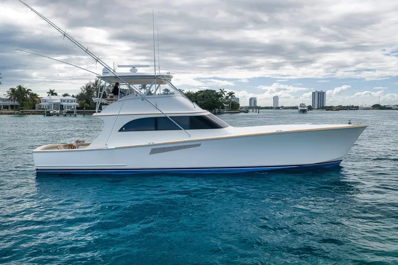 Slide: The Image of 1999 Hines-Farley Sportfisherman yacht on blue water, with coastal skyline in background. - 11