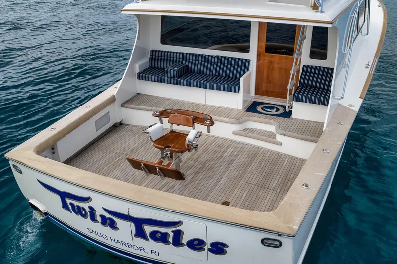 Slide: The Image of 1999 Hines-Farley SPORTFISHERMAN boat with spacious deck and seating, named "Twin Tales." - 23