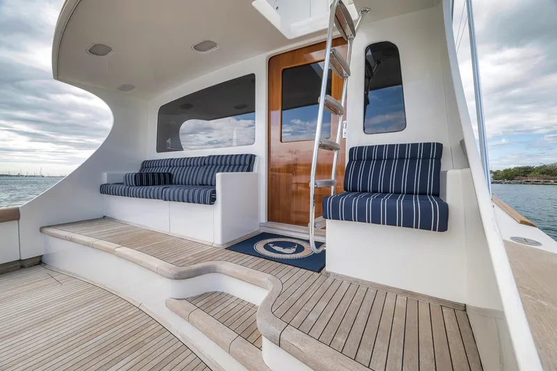 Slide: The Image of 1999 Hines-Farley SPORTFISHERMAN yacht deck with striped seating and wooden accents. - 42