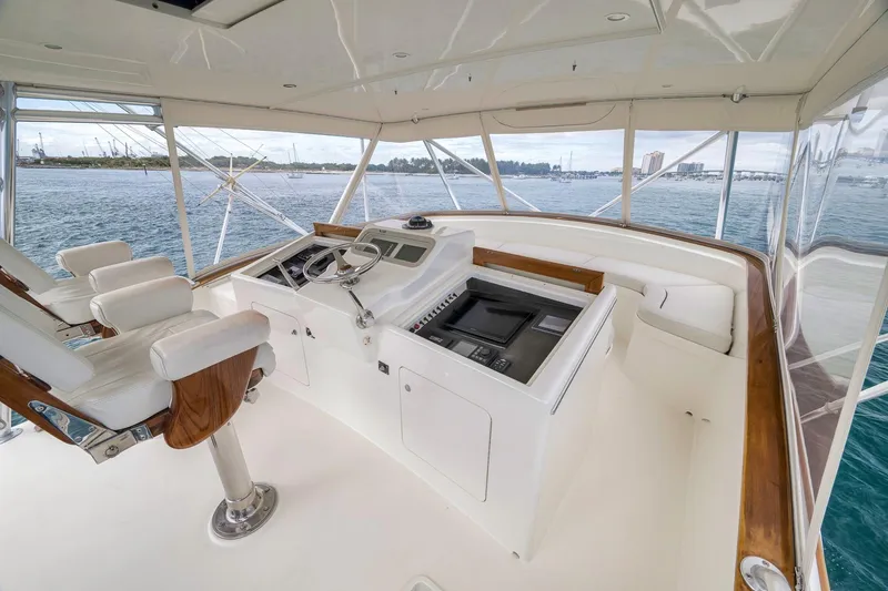 Slide: The Image of 1999 Hines-Farley SPORTFISHERMAN helm with ocean view, featuring white seating and control panel. - 48