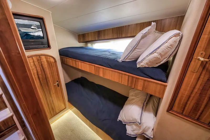 Slide: The Image of 1999 Hines-Farley SPORTFISHERMAN cabin with wooden bunk beds and a small TV. - 50