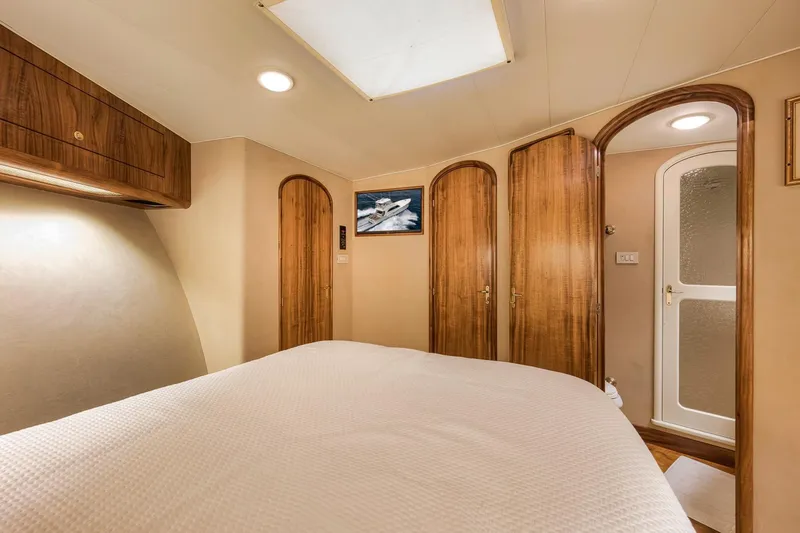 Slide: The Image of Luxurious 1999 Hines-Farley SPORTFISHERMAN yacht cabin with wooden accents and cozy bedding. - 60