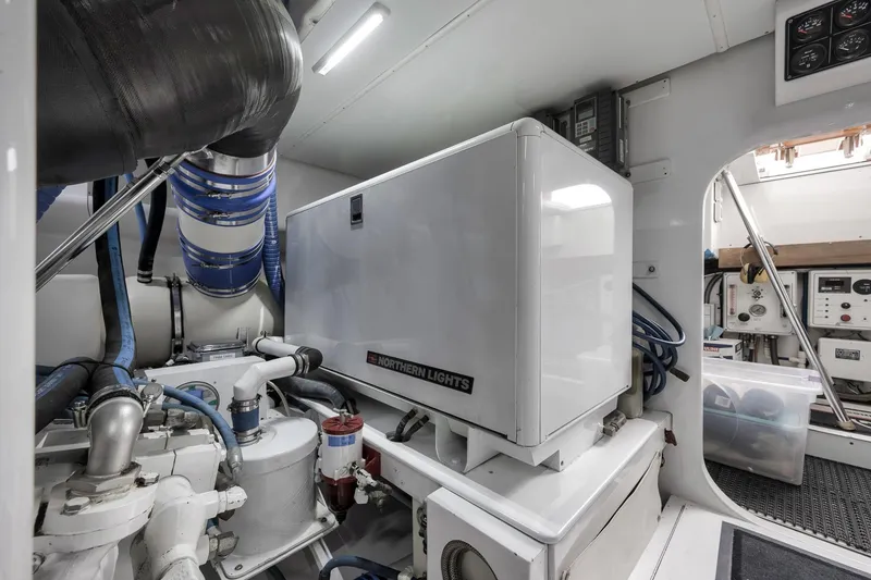 Slide: The Image of Engine room of 1999 Hines-Farley SPORTFISHERMAN with Northern Lights generator and blue hoses. - 80