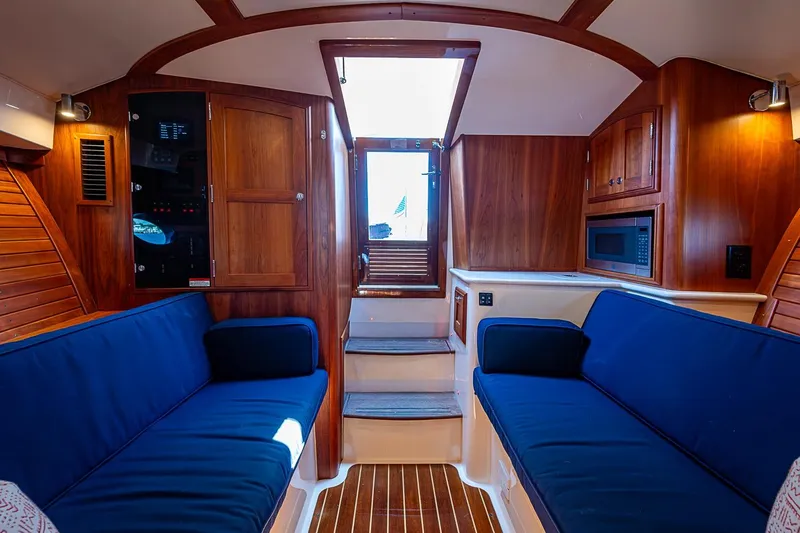 Slide: The Image of Luxurious interior of 2017 Hinckley Talaria 34R yacht with blue seating and wooden finishes. - 12