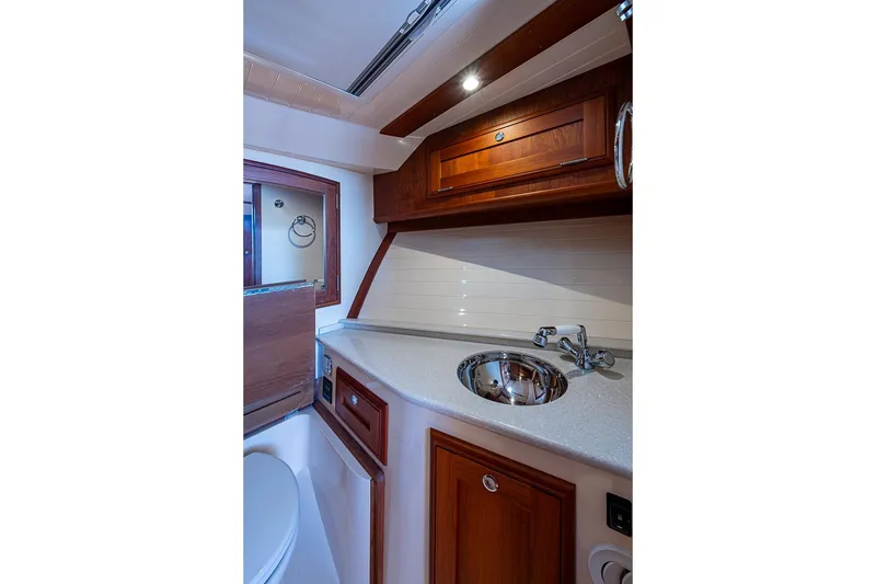 Slide: The Image of Luxurious 2017 Hinckley Talaria 34R yacht bathroom with wooden cabinetry and modern fixtures. - 14
