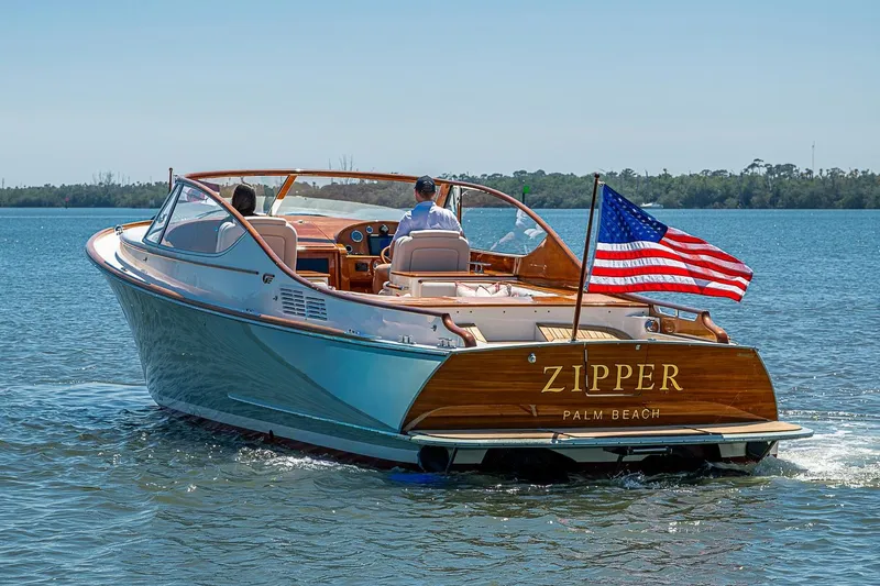 Slide: The Image of 2017 Hinckley Talaria 34R boat named "Zipper" cruising on water with American flag. - 20