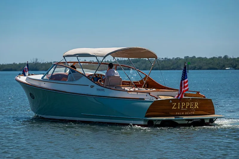 Slide: The Image of 2017 Hinckley Talaria 34R cruising on calm waters, featuring elegant design and American flag. - 21