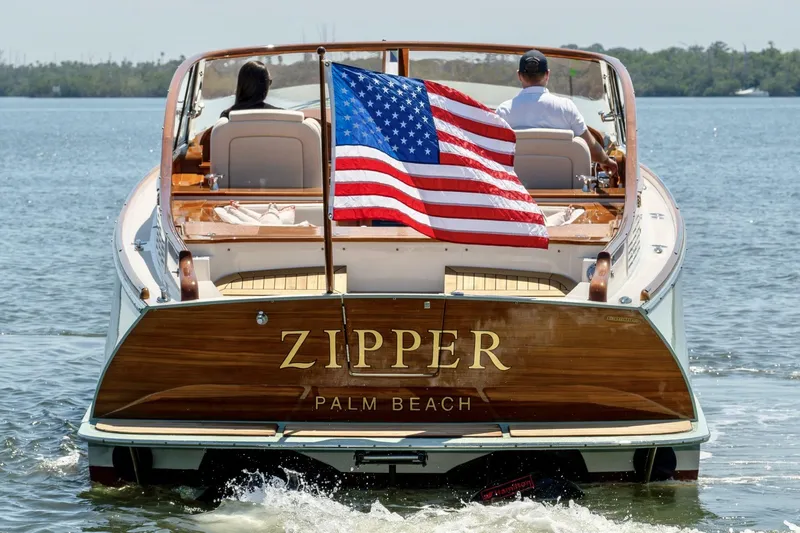 Slide: The Image of 2017 Hinckley Talaria 34R boat named "Zipper" with American flag on water. - 23