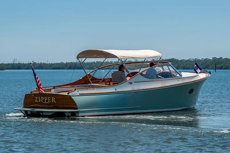 Slide: The Image of 2017 Hinckley Talaria 34R boat cruising on calm water, featuring elegant design and canopy. - 25