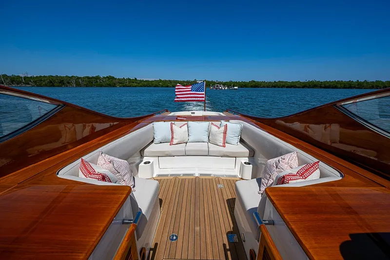 Slide: The Image of Hinckley Talaria 34R 2017 yacht with elegant seating, American flag, and scenic water view. - 6
