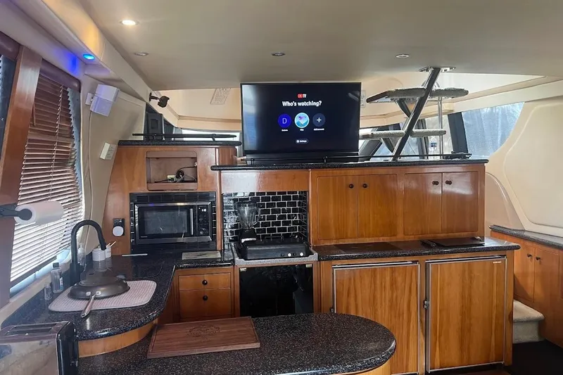 Slide: The Image of Interior of 2000 Carver 530 Voyager Pilothouse with modern kitchen and entertainment setup. - 11