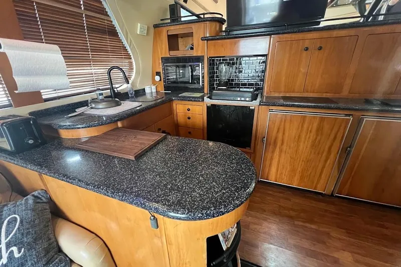 Slide: The Image of Luxurious kitchen interior of 2000 Carver 530 Voyager Pilothouse yacht with wood cabinetry. - 12