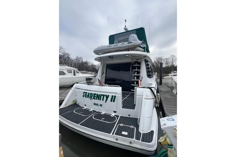 Slide: The Image of 2000 Carver 530 Voyager Pilothouse yacht docked, rear view with "SEARENITY II" name. - 26