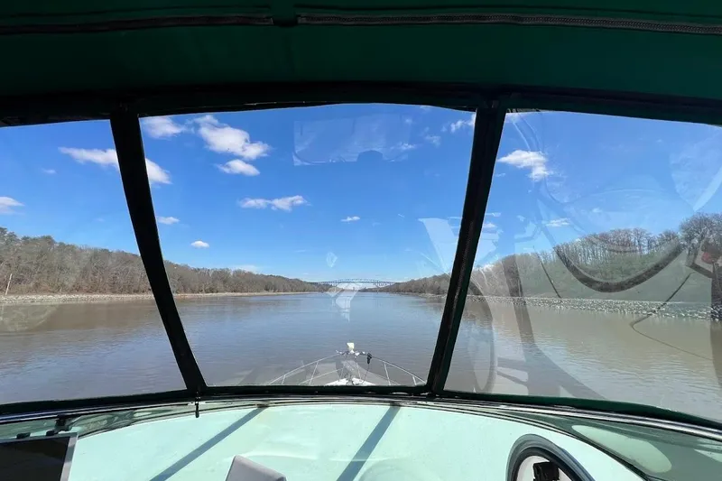 Slide: The Image of View from Carver 530 Voyager Pilothouse, 2000, navigating a calm river under a blue sky. - 6