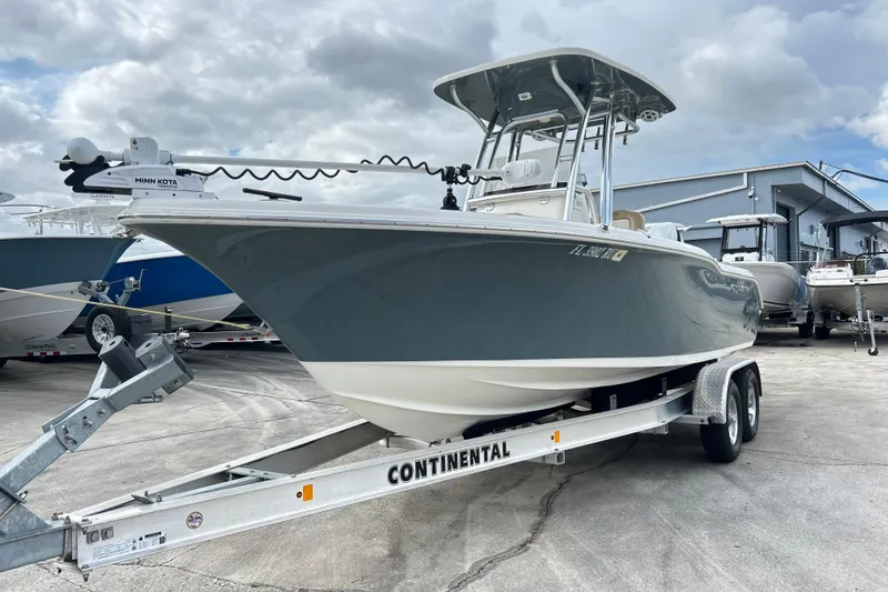 The Image of 2019 Key West 239 FS boat on trailer, parked outdoors under cloudy sky. - 1